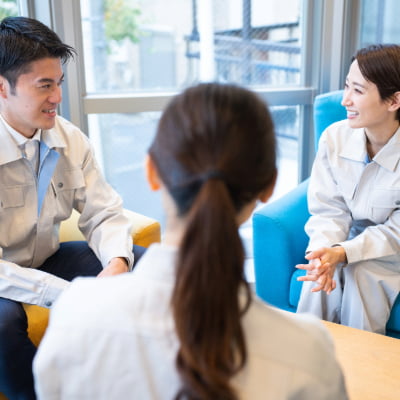 談笑する作業服を着た男女社員