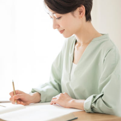 姿勢正しく文章を書く女性